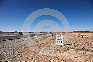 Road to Agadir. Milestone indicating Agadir in a desertic area of Morocco photo
