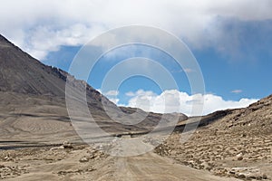 Road to clouds in valley in the foothills of the Fann mountains.