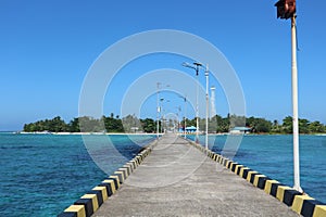 the road to an island from the harbor with a clear blue sky background in ambo island, balak balakang archipelago photo