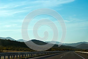 Road to nowhere; empty road and landscape - mountains and sky in background