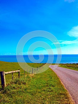 Road to nowhere in Tasmania green grass ocean views blue sky