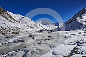 Road to Rumbak Valley and Yarutse, Hemis NP, Ladak, India. River with snow during winter, Himalayas. Mountain landscape in India