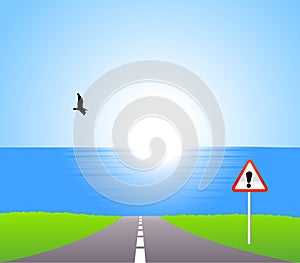 Road to sea with attention sign