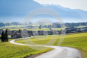 Road to Austrian mountain village with foggy valley background in autumn, Wildermieming, Tirol, Austria