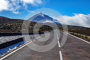 Road to Teide volcano peak at dusk with misty clouds