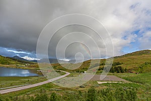 Road to Unstad under colorful Rainbow in Lofoten islands, Norway, selective focus