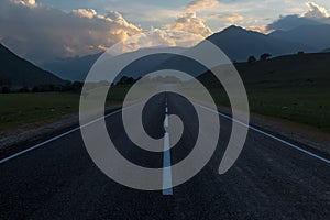 Road towards the mountains at sunset