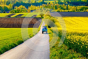 Cesta s traktorem v krásném kraji s květinovými loukami a poli. Slovensko, střední Evropa, Liptov.