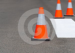 Road traffic cones standing on street on gray asphalt during road construction works. Traffic cones for road works