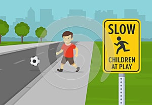 Road or traffic safety rule. Kid playing football near city road. Close up view of slow down, children at play warning sign.