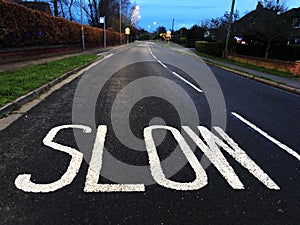 A road traffic sign painted on the road instructing vehicles to slow down