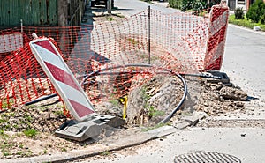 Road traffic sign work ahead with red and white barriers on the street construction site in the city and orange safety net for int