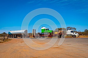 Road Train in Australia carrying another truck and fuel in the Outback