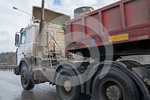 Road train driving on a wet road close-up