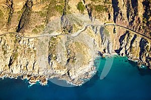 The road less traveled. Aerial shot of a road running along the rugged coastline of the western cape.