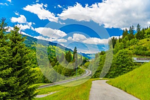 Road with trees among Alps mountains, Klosters-Serneus, Davos, Graubuenden Switzerland