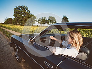 Road trip. Female driver in muscle car on journey.