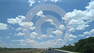 Road trip, fluffy white clouds, country road driving