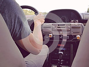 Road trip with friends concept, car interior seen from the passenger`s seat, hand of the driver on the steering wheel