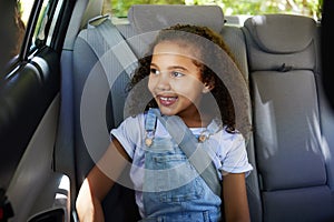 Road trip, girl child and happy in car backseat for travel, journey and drive, happy and relax. Smile, kid and little