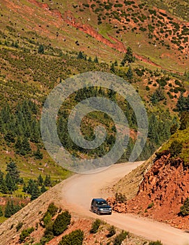 Road trip in the mountains solitary suv on dirt road