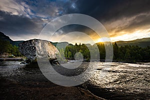 Road trip rest stop Large Boulder in  Otra river Scandinavian landscape at sunrise, Valle Norway photo