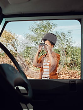Road trip, travel and binoculars with a sightseeing woman outdoor in nature for a summer vacation or weekend getaway