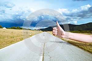 Road trip, travel, gesture and people concept - woman hitchhiking