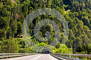 Road tunnel in Alpine mountains, Switzerland. Panoramic view of entrance of tunnel in Alps