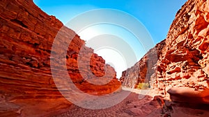 road between two red rocks located in the desert