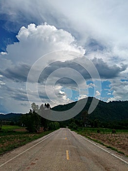 Road under a blue sky with soft clouds.