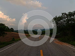 Road under a blue sky with soft clouds.