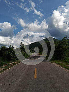 Road under a blue sky with soft clouds.