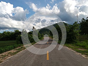 Road under a blue sky with soft clouds.