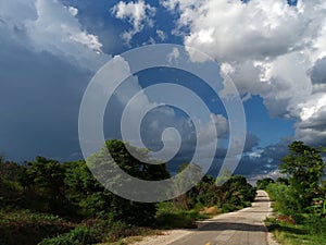 Road under a blue sky with soft clouds.