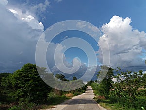 Road under a blue sky with soft clouds.