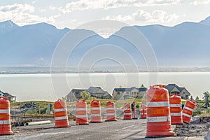 Road under construction with blurry view of homes lake and mountain against sky