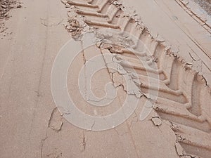 Road under construction vehicle footprint on sand