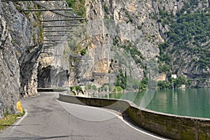 Road under rocks at a lake