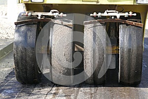 Road vibratory rollers powerfully compact fresh asphalt on a road construction site against the background of a city