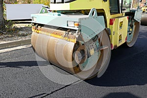 Road vibratory rollers powerfully compacting fresh asphalt on a road construction site on a city street photo