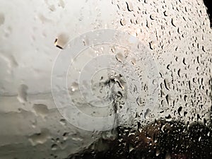 Road view through car window blurry with rain, Driving in rain