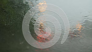 Road view through car window with rain drops