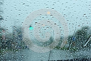 Road view through car window with rain drops