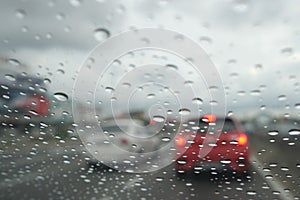 Road view through car window with rain drops driving in rain.