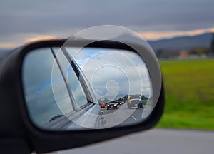 Road view in side mirror on a car