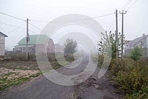 The road in the village in the fog in the morning