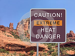 Road warning sign CAUTION! EXTREME HEAT DANGER with mountain