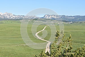 The road winding and disappearing at the distance,the Durmitor mountain at the background