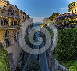 The road winds down to the harbour through a cleft in the cliff line in Sorrento, Italy on the Amalfi coast